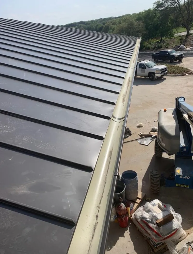 Standing seam panel and gutter detail on a metal roofing jobsite in Milford